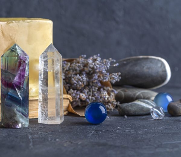 Magic still life with fluorite, quartz crystal and pink candle. Magic rocks for mystic ritual, witchcraft Wiccan or spiritual practice (healing). Meditation reiki. Ritual for love and chakra balance